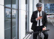 man zit op de fiets en lees op zijn telefoon