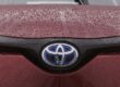 Toyota-logo op een rode auto met regendruppels, symbool van innovatie en betrouwbaarheid – toyota weetjes