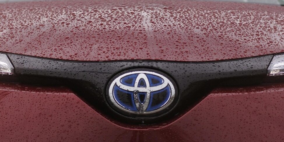 Toyota-logo op een rode auto met regendruppels, symbool van innovatie en betrouwbaarheid – toyota weetjes