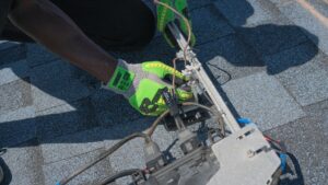 Monteur sluit elektrische bekabeling aan op een dakinstallatie, voorbeeld van beschermingsklasse bij buiteninstallaties