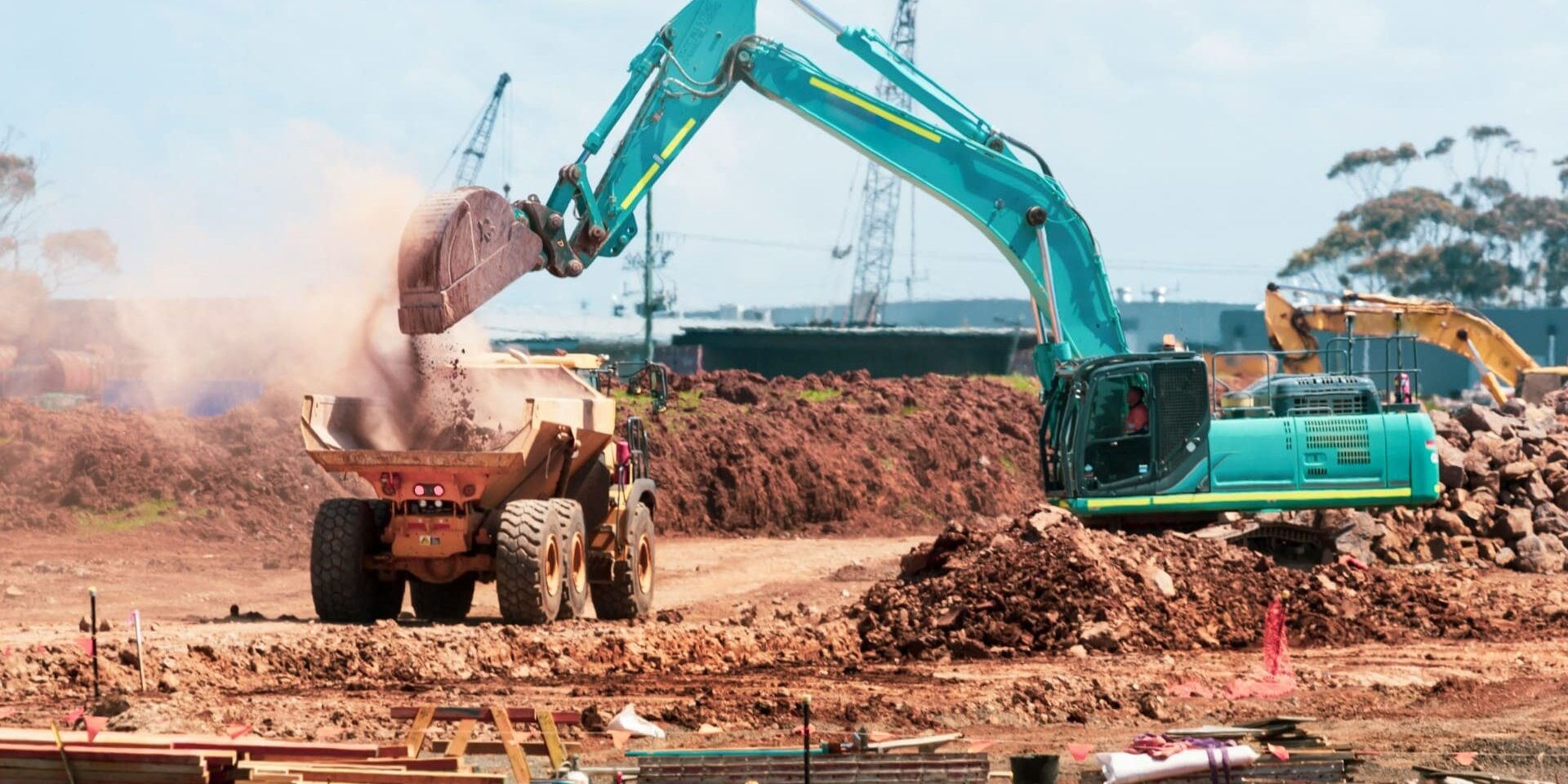 Graafmachine verplaatst grond op bouwplaats tijdens ruwbouwfase van een nieuw bouwproject