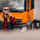 Chauffeur naast vrachtwagen controleert planning volgens rij en rusttijden