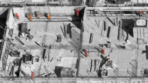 Bouwvakkers werken aan betonnen vloerconstructie tijdens ruwbouw van een gebouw