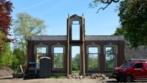 Een huis dat verbouwd wordt waarvan alleen de monumentale gevel is blijven staan