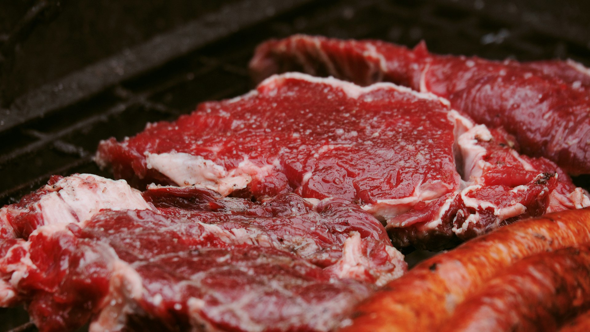 Rood rundvlees en chorizo bestrooid met grof zout op een Argentijnse BBQ