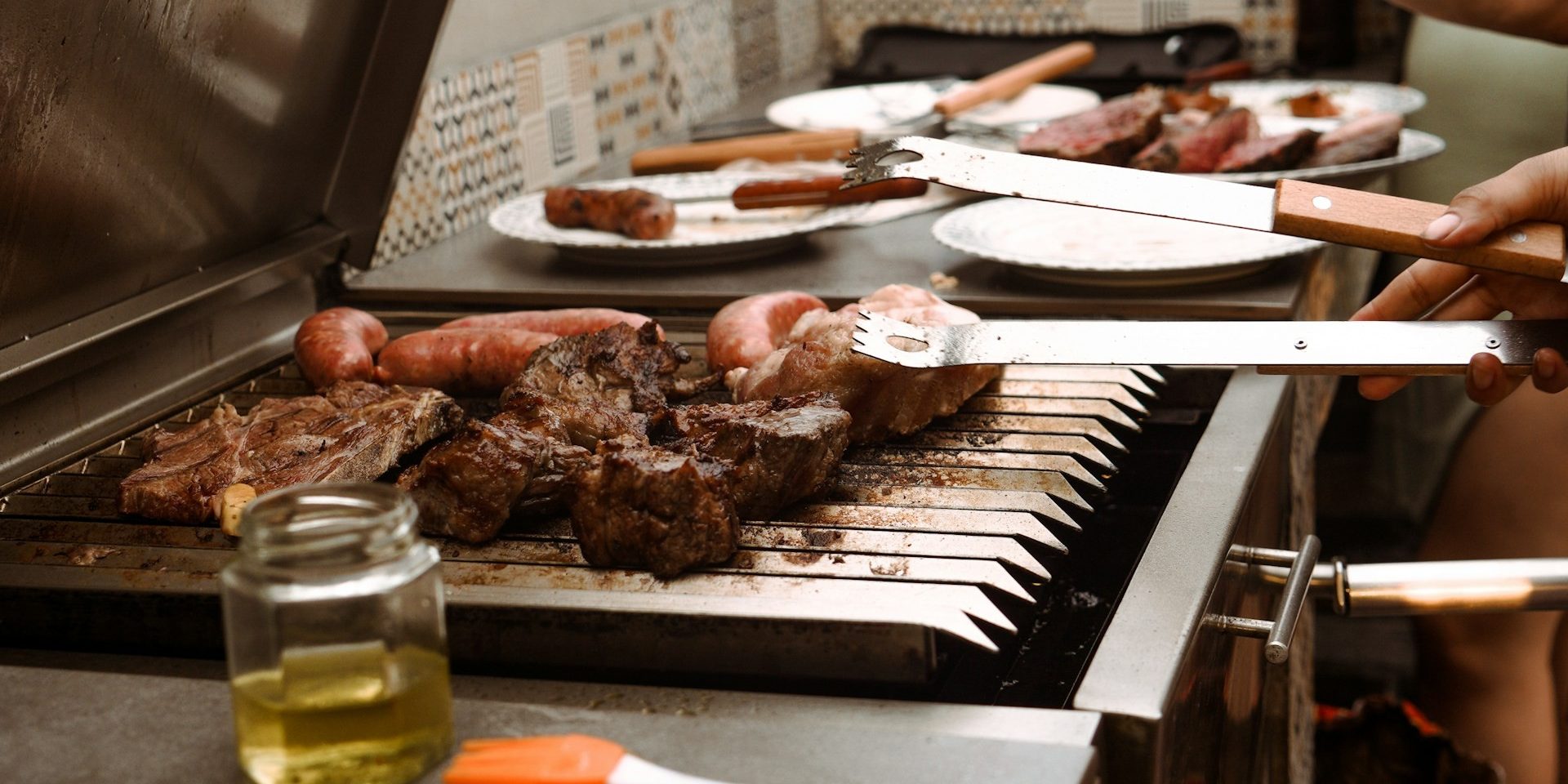 asado-argentijnse-bbq-vlees-en-worst Asado op de parrilla met steaks en chorizo tijdens een Argentijnse BBQ