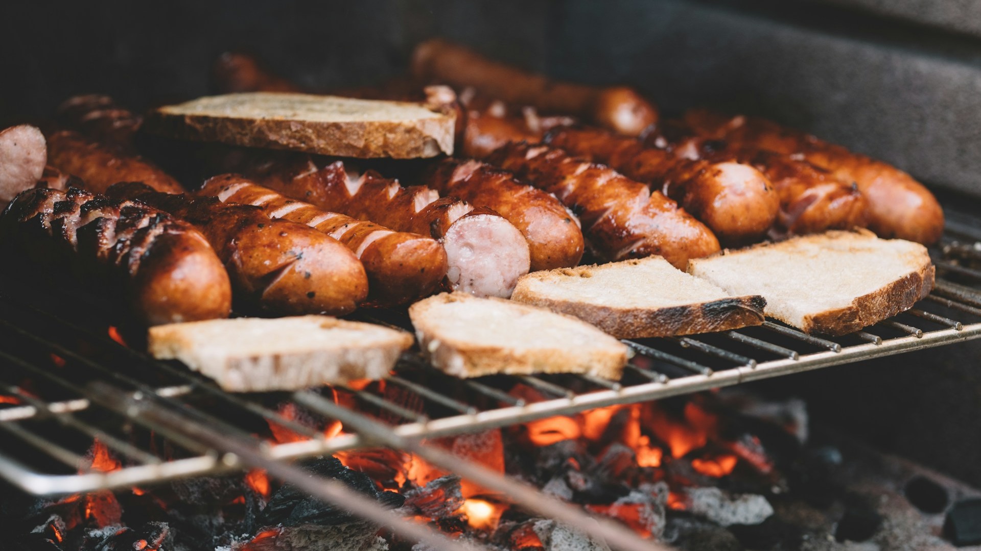 Chorizo en sneetjes brood grillen boven houtskool op een Argentijnse BBQ