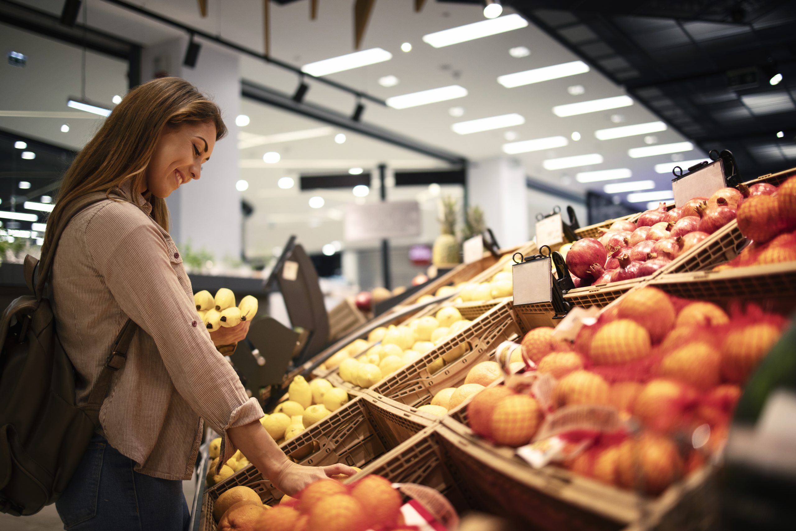 vrouw koopt mandarijnen in de supermarkt