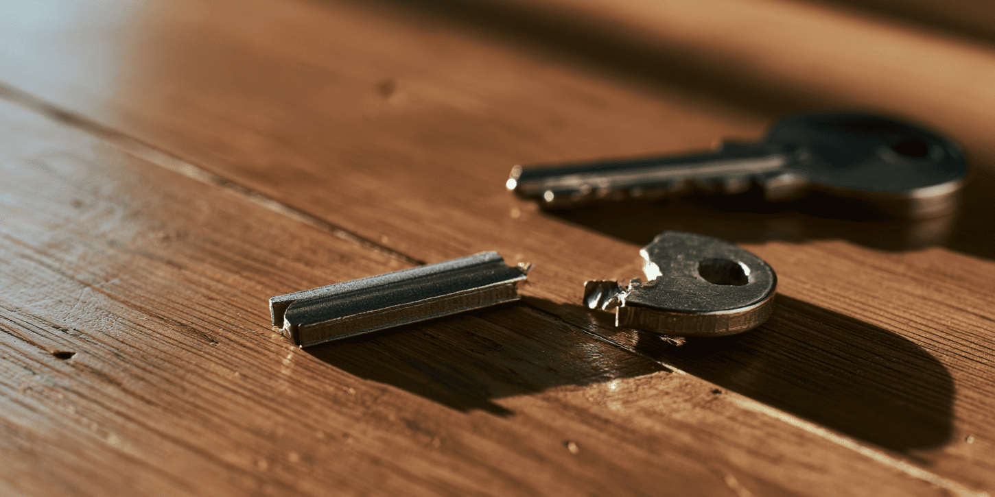 Gebroken huissleutel in twee delen op een houten tafel